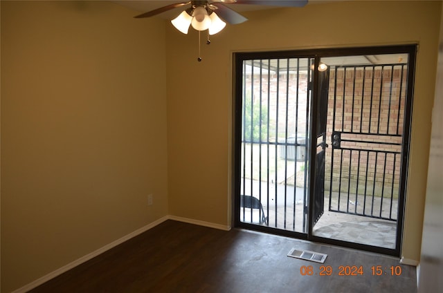 spare room with a ceiling fan, wood finished floors, visible vents, and baseboards