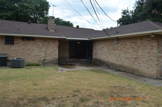 back of house featuring a yard and central AC