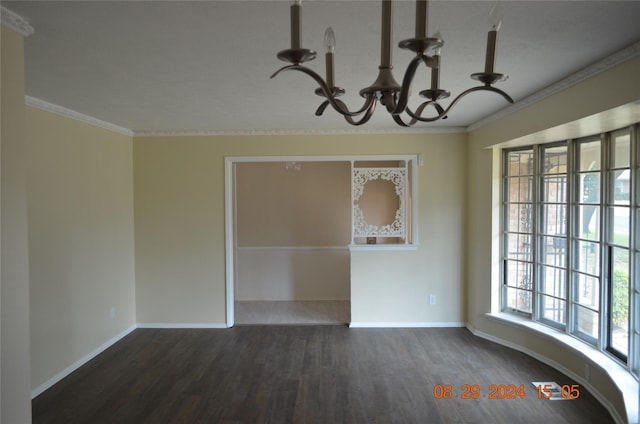 unfurnished dining area featuring crown molding, a notable chandelier, wood finished floors, and baseboards