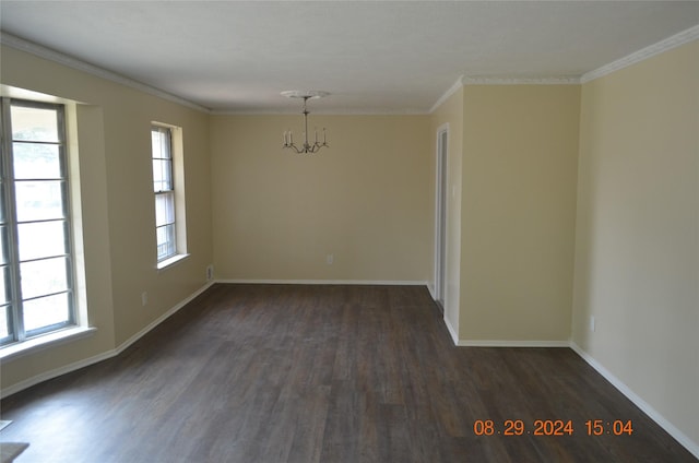 unfurnished room with an inviting chandelier, wood finished floors, baseboards, and ornamental molding