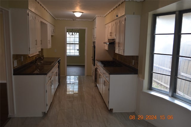 kitchen featuring plenty of natural light, white cabinetry, and tasteful backsplash