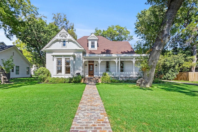 victorian-style house featuring a front yard and a porch