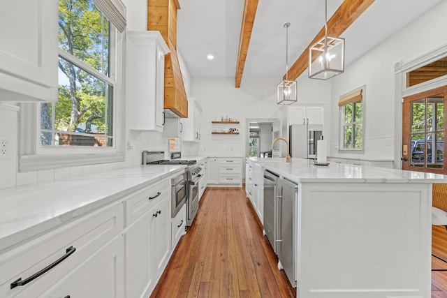 kitchen featuring appliances with stainless steel finishes, white cabinetry, beamed ceiling, light wood-type flooring, and decorative light fixtures