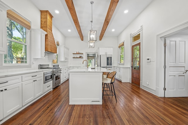 kitchen featuring an island with sink, white cabinetry, high end stove, and dark hardwood / wood-style flooring