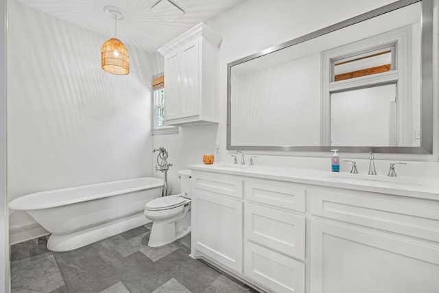 bathroom featuring vanity, a washtub, and toilet