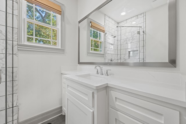 bathroom featuring vanity, plenty of natural light, and tiled shower