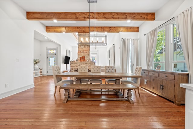 dining space featuring beamed ceiling, light hardwood / wood-style flooring, and a notable chandelier