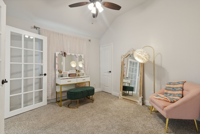 living area with lofted ceiling, carpet, and a ceiling fan