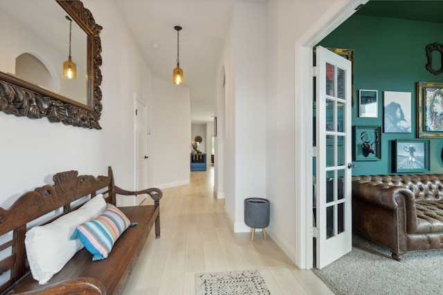 hallway featuring light hardwood / wood-style floors and vaulted ceiling