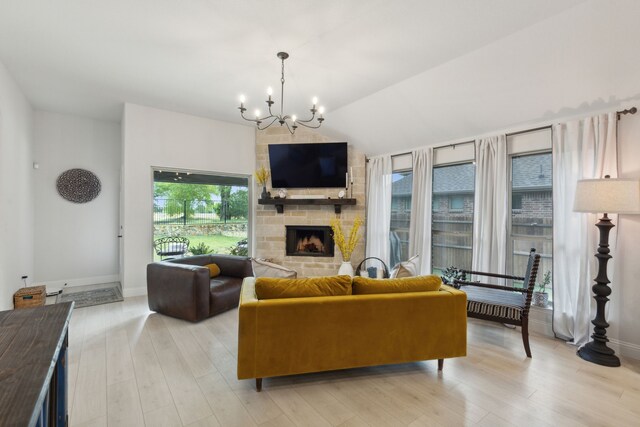 living room with a chandelier, light hardwood / wood-style flooring, and a fireplace