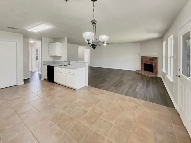 kitchen featuring hanging light fixtures, dishwasher, light hardwood / wood-style flooring, a chandelier, and sink