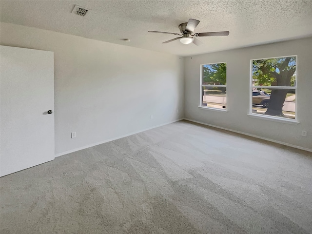 carpeted spare room featuring a textured ceiling and ceiling fan