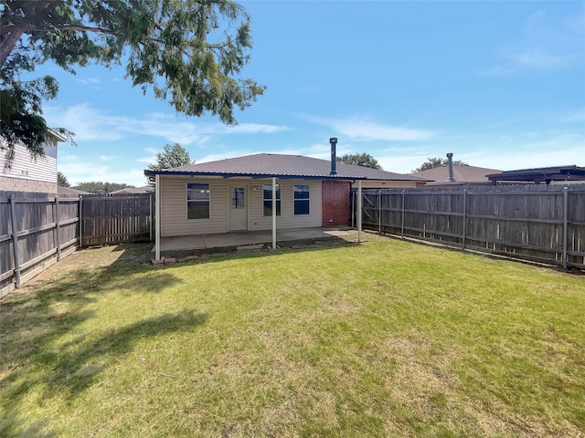 rear view of house with a yard and a patio area