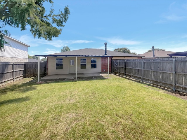 back of house featuring a yard and a patio area