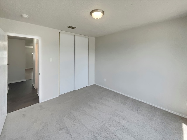 unfurnished bedroom featuring a closet, carpet, and a textured ceiling