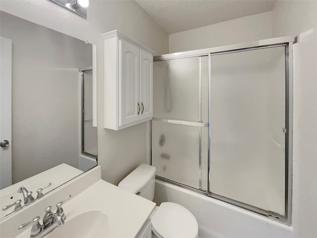 full bathroom with shower / bath combination with glass door, toilet, a textured ceiling, and vanity