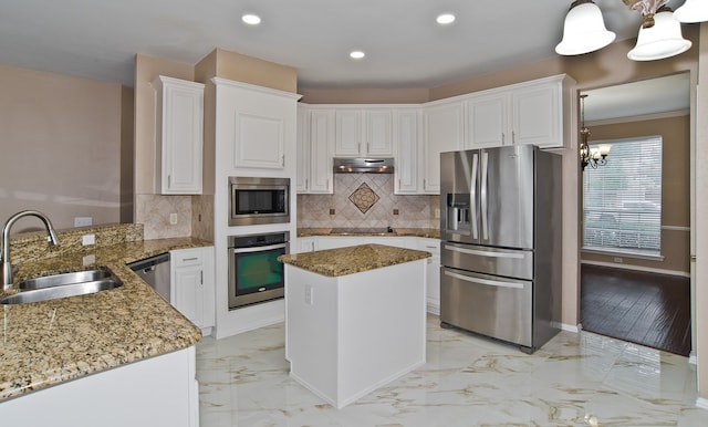 kitchen with stone counters, a chandelier, sink, appliances with stainless steel finishes, and white cabinets