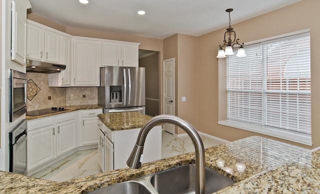 kitchen featuring dark stone countertops, pendant lighting, white cabinetry, stainless steel appliances, and sink