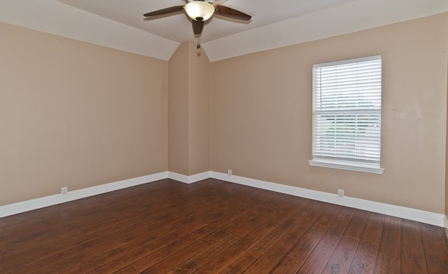 empty room with dark hardwood / wood-style flooring, ceiling fan, and vaulted ceiling