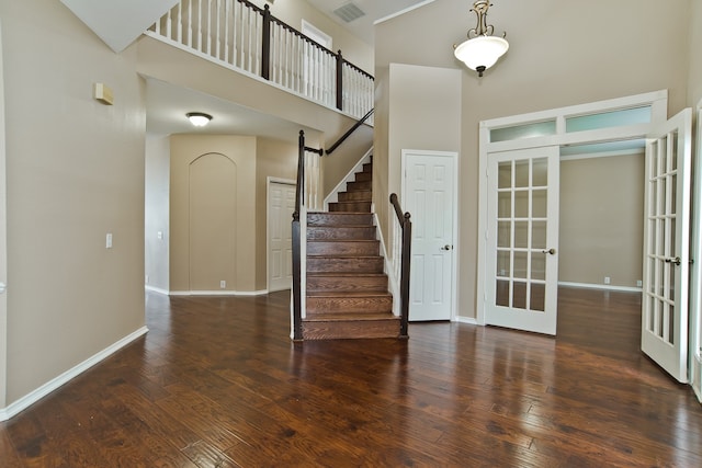 entrance foyer with french doors, a high ceiling, and dark hardwood / wood-style floors