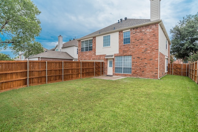 rear view of property featuring a yard and a patio area