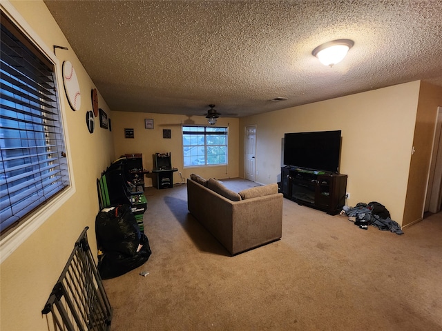 living room with a textured ceiling, ceiling fan, and carpet flooring