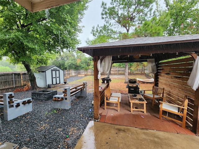 view of patio featuring a storage unit, area for grilling, an outdoor living space with a fire pit, and a gazebo