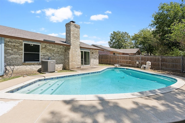 view of swimming pool with a patio area, a diving board, and cooling unit