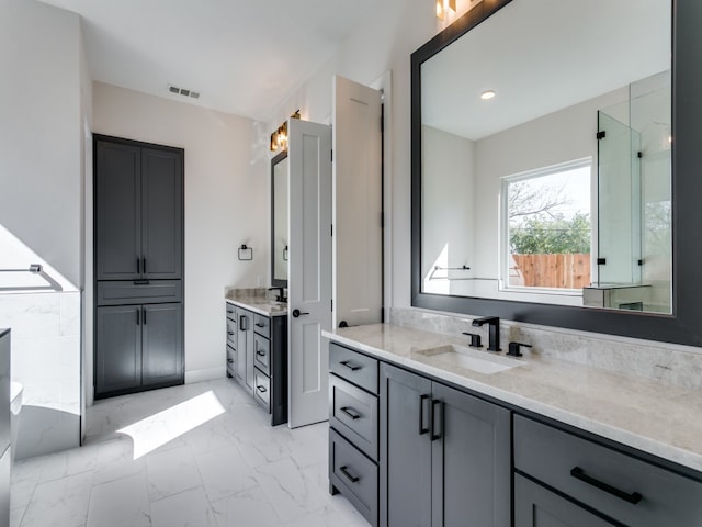 bathroom featuring vanity and a shower with door