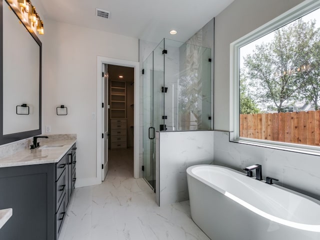 bathroom with vanity and shower with separate bathtub