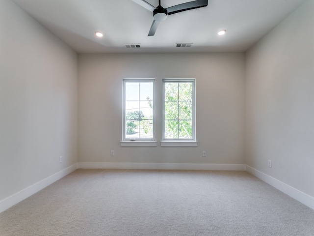 spare room featuring ceiling fan and light carpet