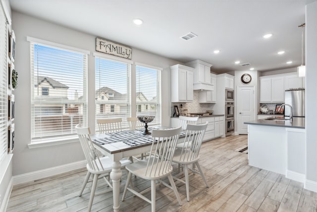 dining space featuring sink and light hardwood / wood-style floors