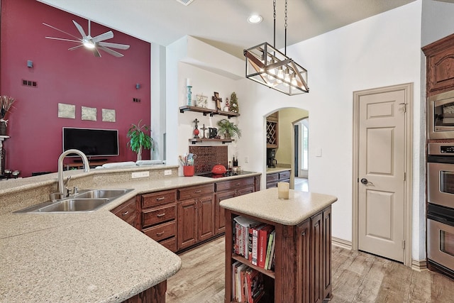 kitchen with a kitchen island, ceiling fan, sink, and light hardwood / wood-style floors