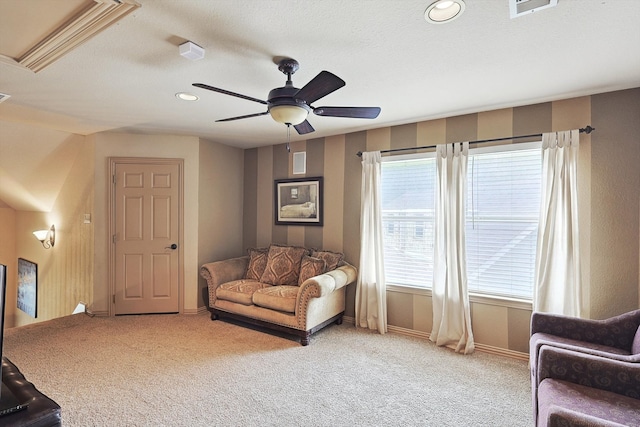 sitting room with light carpet, a textured ceiling, and ceiling fan