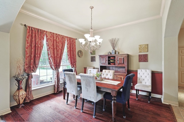 dining room featuring crown molding, dark hardwood / wood-style flooring, and an inviting chandelier