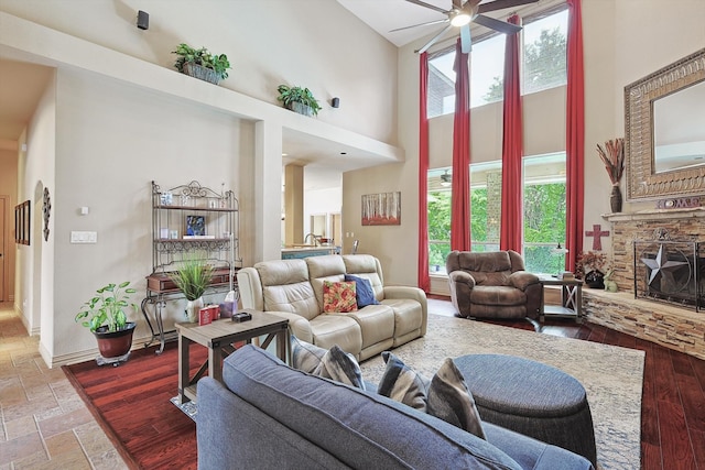 living room featuring plenty of natural light, wood-type flooring, high vaulted ceiling, and ceiling fan