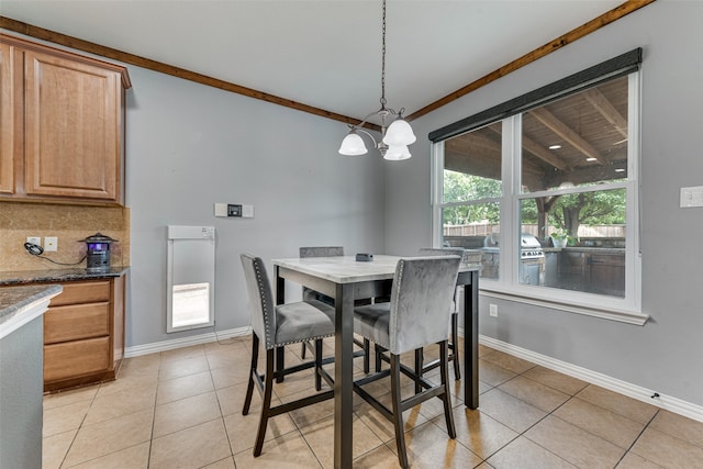 dining room featuring crown molding, a notable chandelier, and light tile patterned flooring