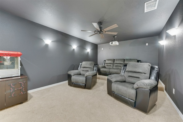 carpeted cinema featuring a textured ceiling and ceiling fan