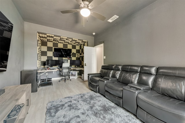 home theater room with ceiling fan and light hardwood / wood-style floors