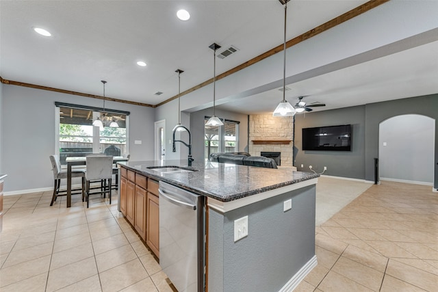 kitchen featuring a kitchen island with sink, a fireplace, sink, ceiling fan, and stainless steel dishwasher