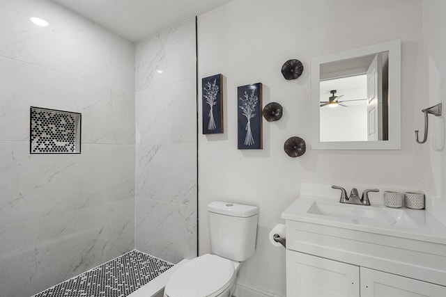 bathroom featuring vanity, toilet, a tile shower, and ceiling fan