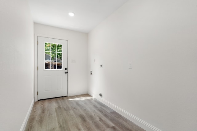 doorway to outside featuring lofted ceiling and light wood-type flooring