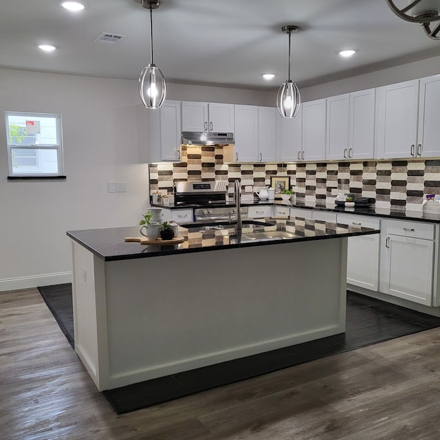 kitchen featuring hanging light fixtures, dark hardwood / wood-style flooring, and a kitchen island with sink