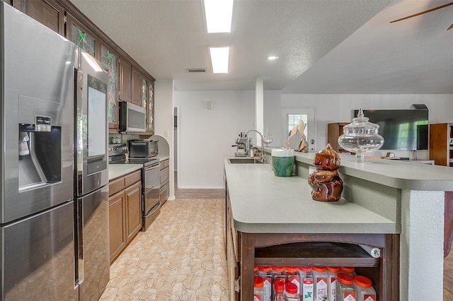 kitchen featuring a textured ceiling, sink, and stainless steel appliances