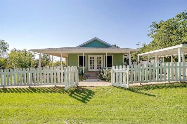 rear view of house with french doors and a lawn