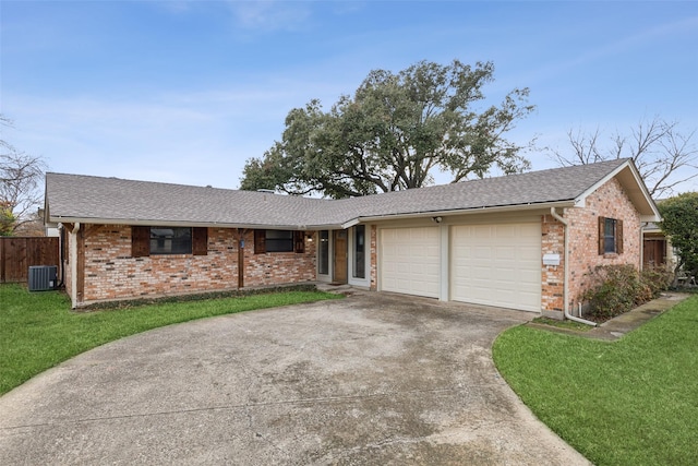 ranch-style house featuring a garage, central AC unit, and a front lawn