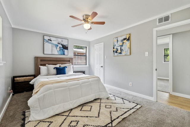 bedroom with ceiling fan, ornamental molding, carpet, and multiple windows