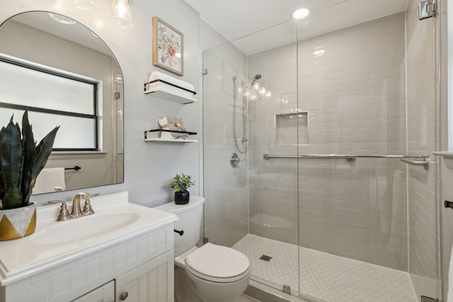 bathroom with walk in shower, vanity, and toilet