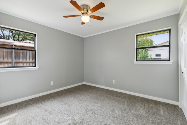 carpeted empty room with ceiling fan and ornamental molding