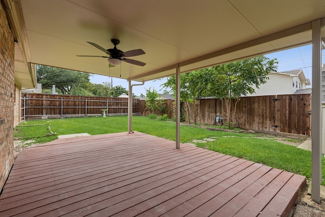 wooden deck with a lawn and ceiling fan